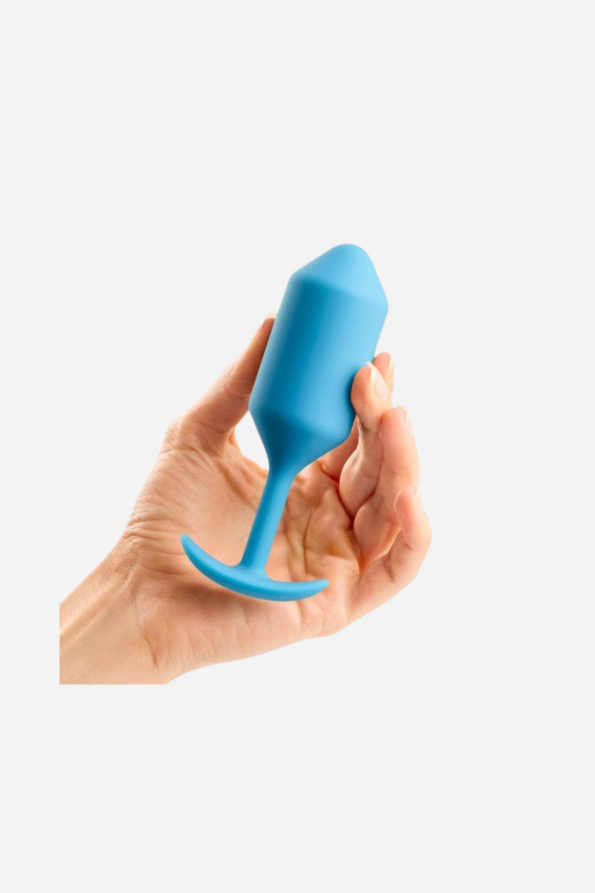 Hand holding the B-Vibe Snug Plug 3 weighted butt plug in Teal, showing its bulb shape and slim neck above the flared T-base