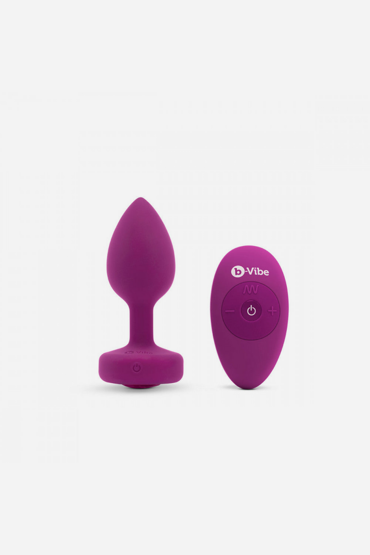 Pink B-Vibe Vibrating Jewel Plug standing next to its wireless remote, which switches between 6 vibration speeds and 15 vibration patterns