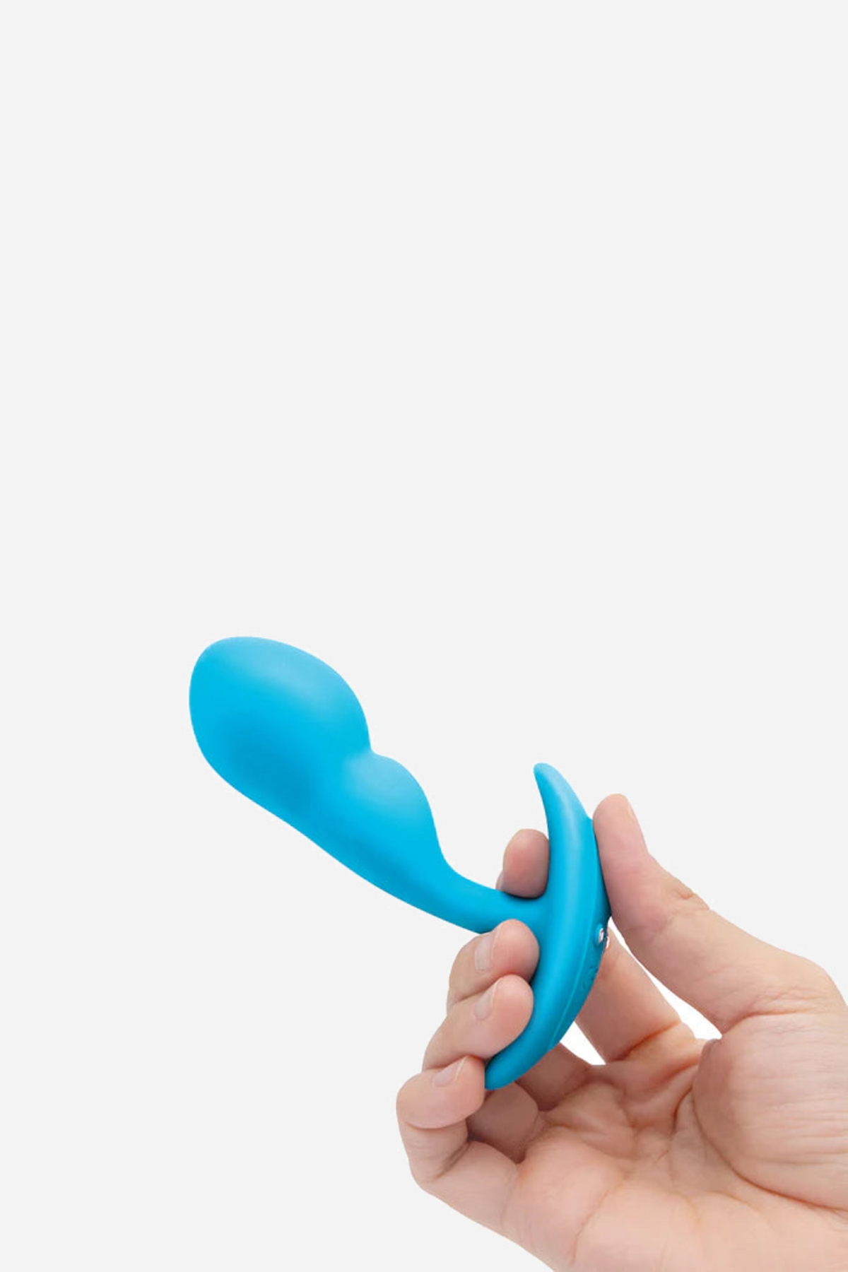 Hand bending the base of the blue B-Vibe Snug Plug 1 between fingers to show its soft, flexible silicone neck for comfortable longer wear