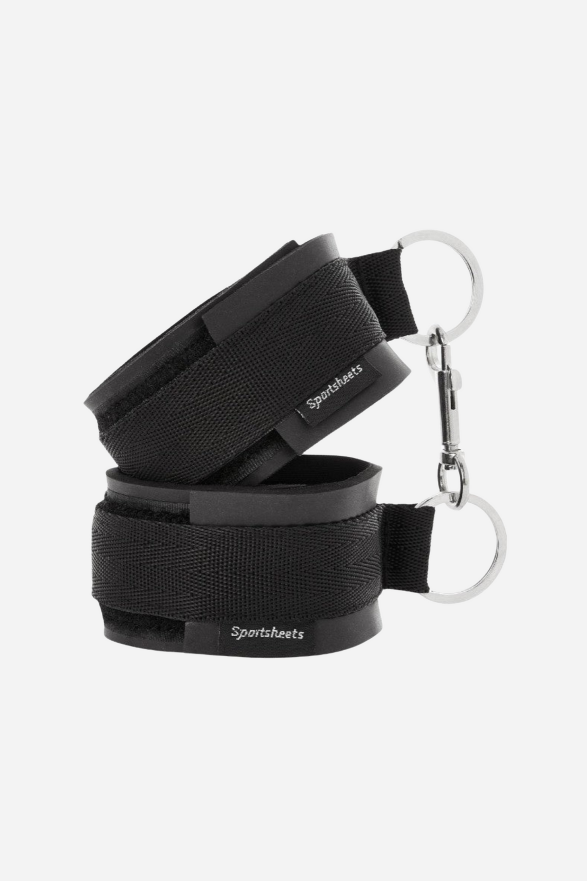 Pair of black padded Bound in Love soft cuffs on grey, each with a hook and loop strap and a silver D-ring and clip at the side.
