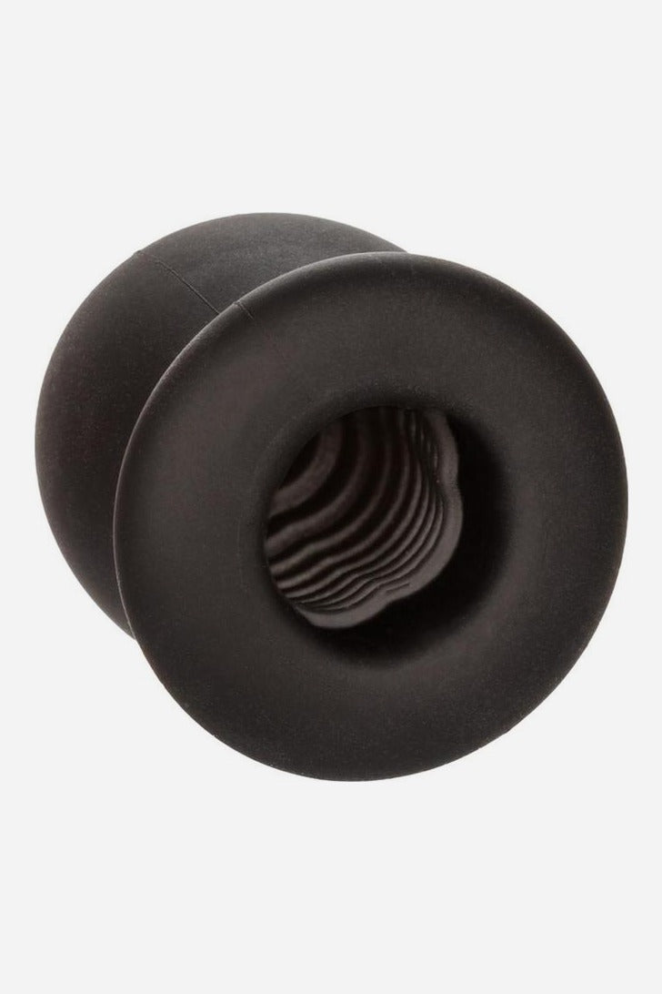 Open end of the black Boundless FTM silicone stroker tilted to show the soft ribbed and textured inner channel through its round opening