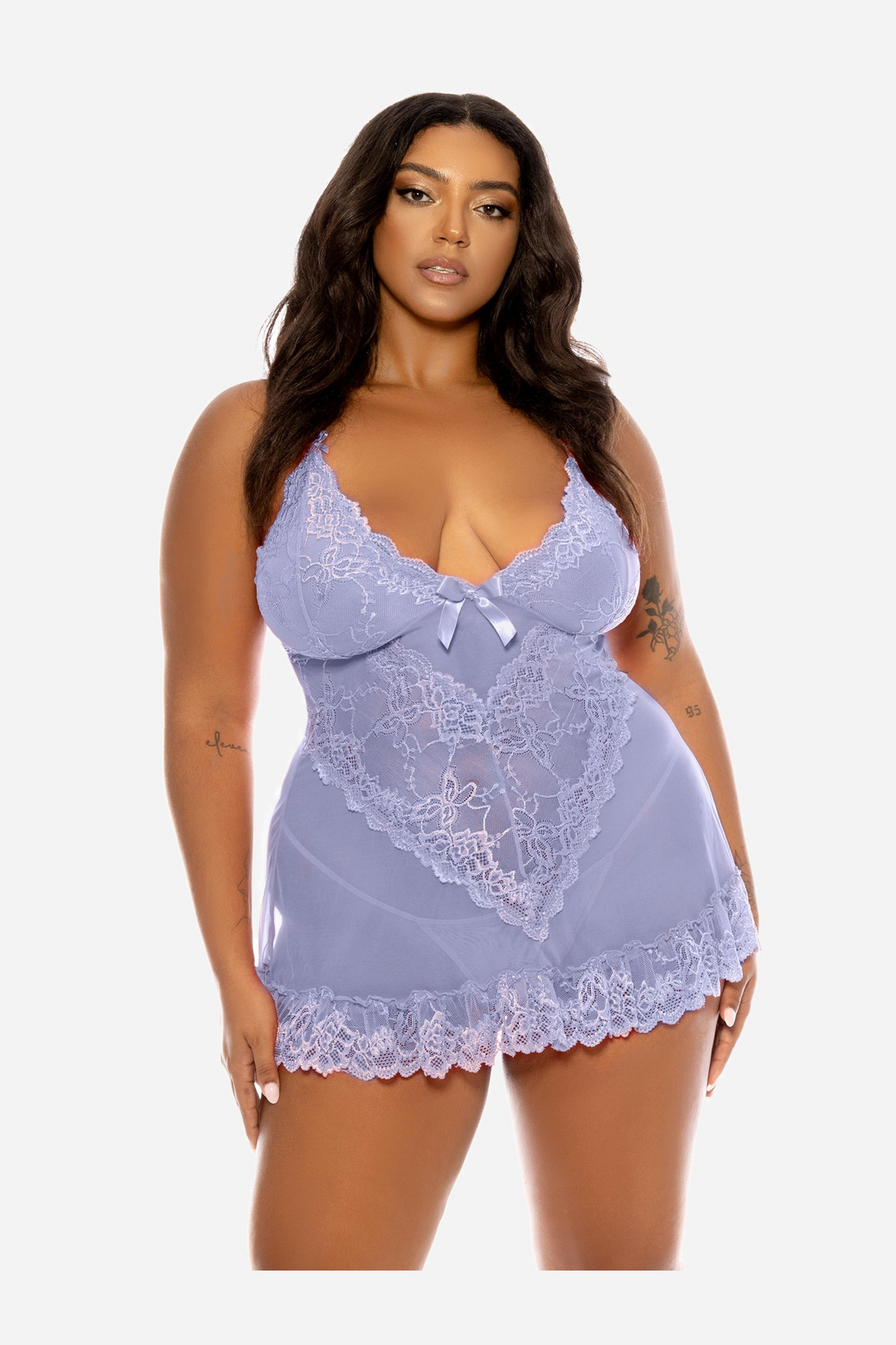 Plus-size model in the Brunnera blue lace babydoll seen from the front, its scalloped cups, satin bow and flared mesh hem visible.