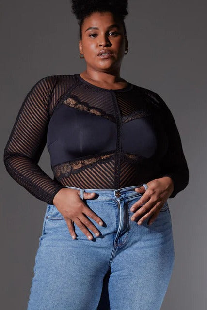 Plus-size model wearing Chelsea's High Line sheer striped long-sleeved bodysuit styled with light-wash high-waist jeans