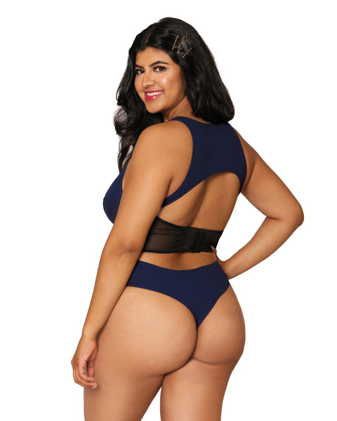 size extra large model smiles showing off the open back of the cozy corseted teddy in navy mesh center panels