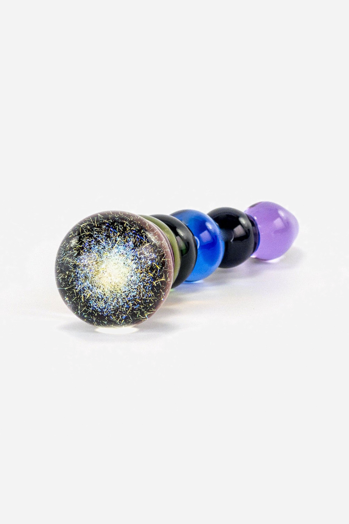 The rainbow glass bubble dildo stood on its speckled gold end bulb on grey, the blue and purple beads receding behind it in a line.