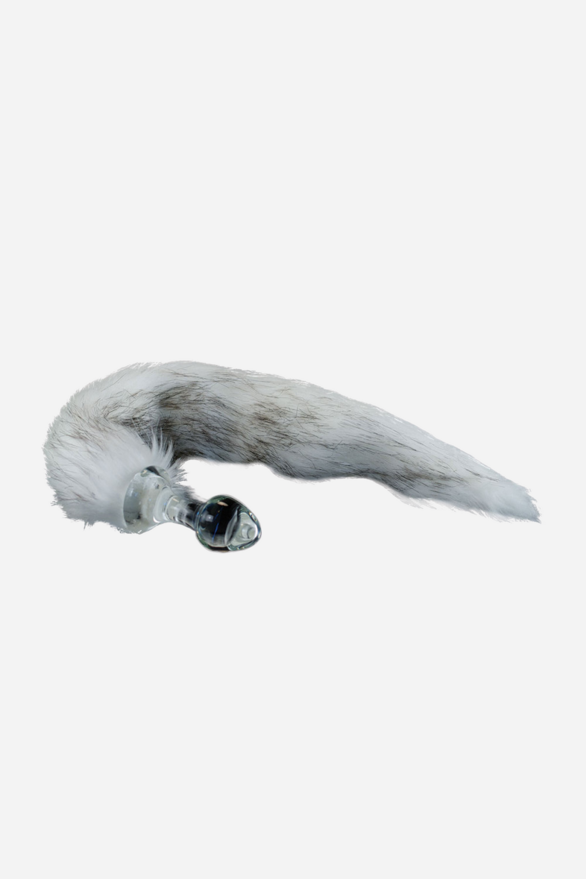 A clear glass plug with a long grey and white husky tail attached at its base, the fur fanning out across a pale grey ground.