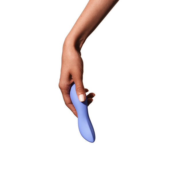 view of a brown hand holding the dame dip sex toy. toy is slightly longer than a hand