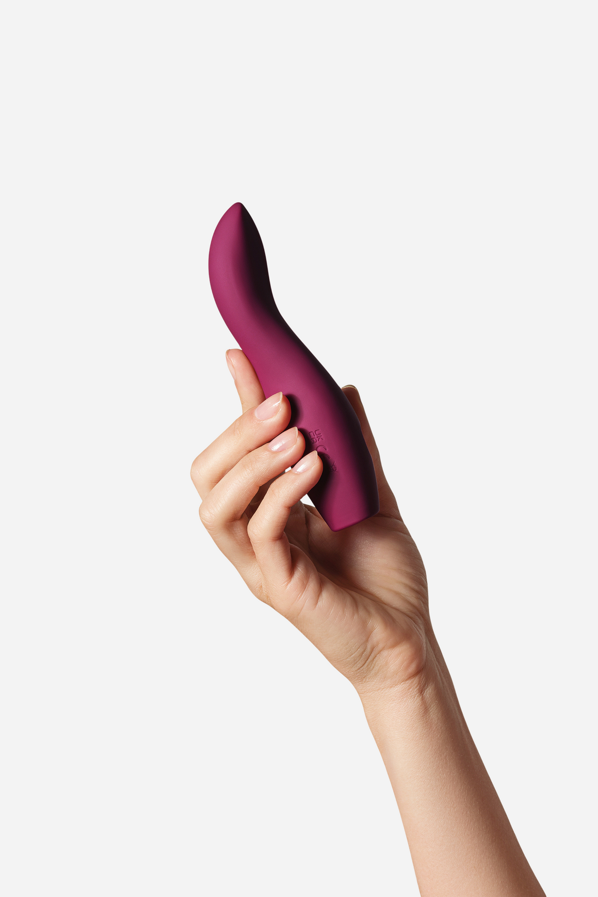Hand holding the Dame Dip 2.0 Beginners Palm Vibe in plum, showing its curved, flexible tapered tip designed for easy external play