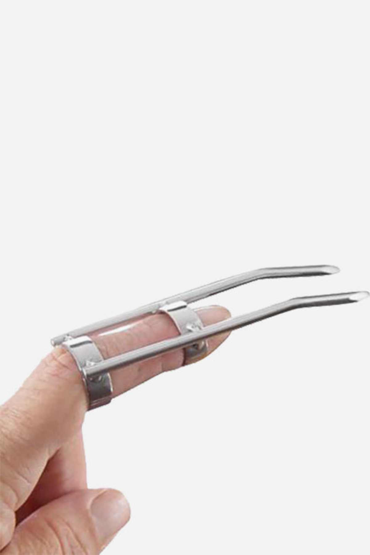 Hand wearing a stainless steel finger claw: two metal bands around the index finger hold two long rods with rounded tips, on a light grey background.