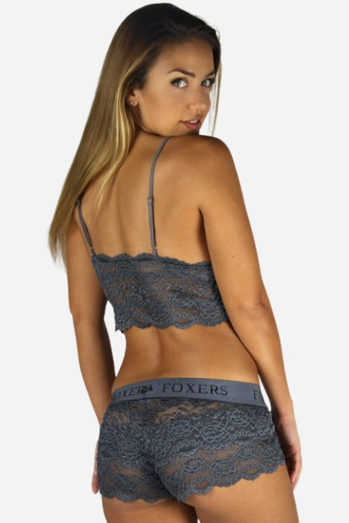 Model looking over her shoulder in charcoal gray Foxers lace boxers with a gray FOXERS waistband and a matching lace bralette, back view