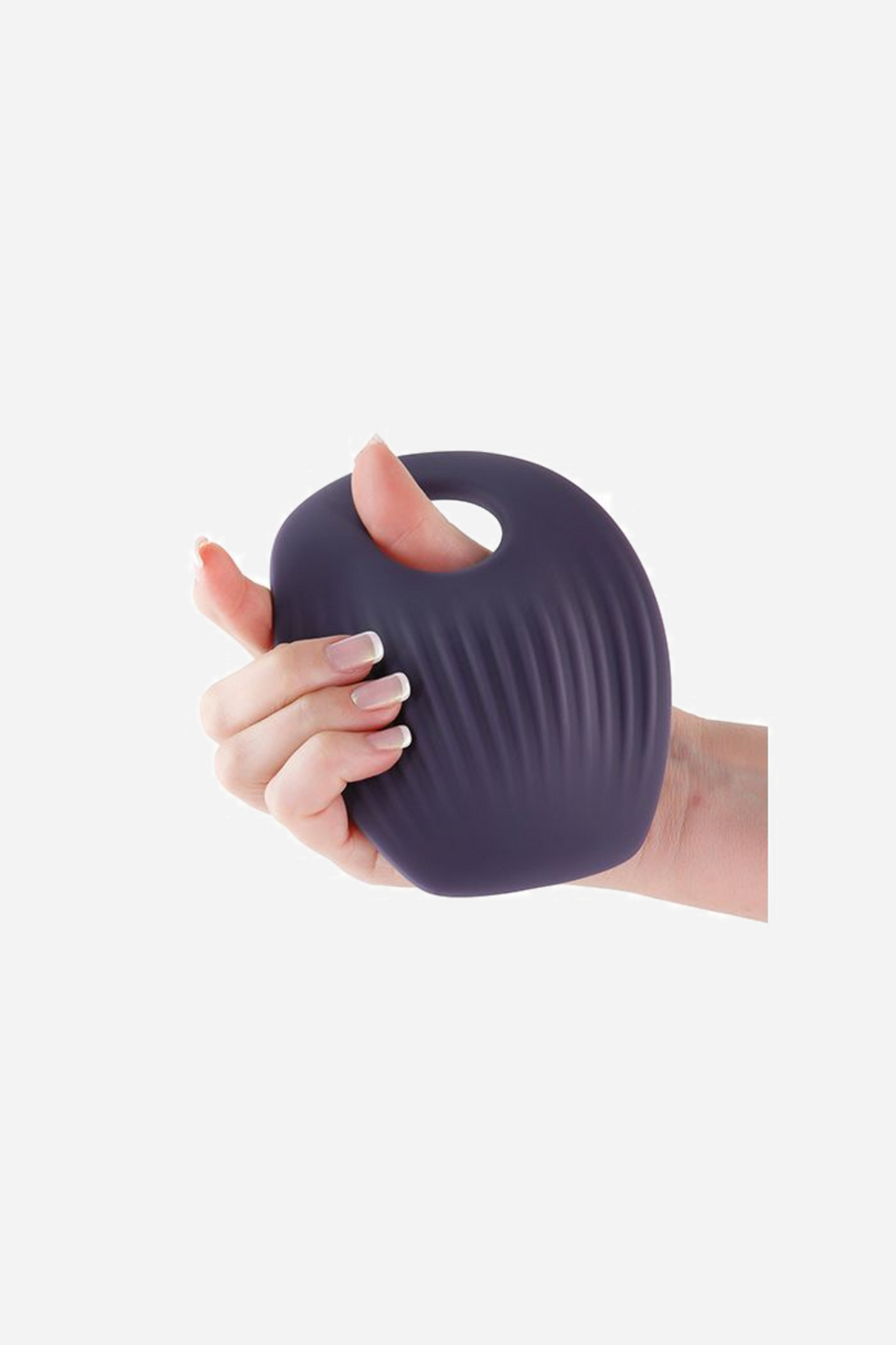 A hand squeezing the purple Get In Ya grinding pad on grey, fingers pressing into the ribbed silicone to show how soft it is.