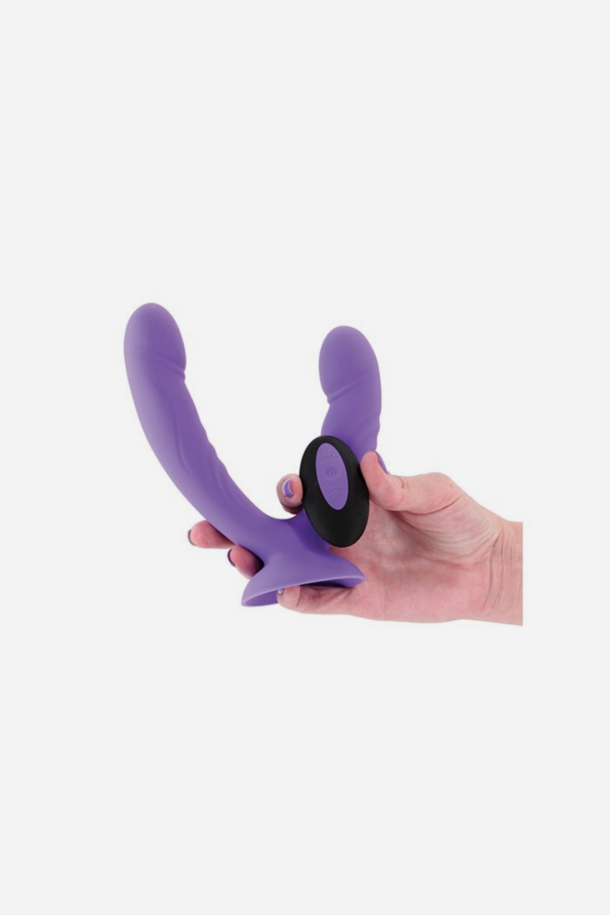 Hand holding the purple Get In Ya Vibrating Grinding Dual Dildo and its black remote, giving a clear sense of the toy's size