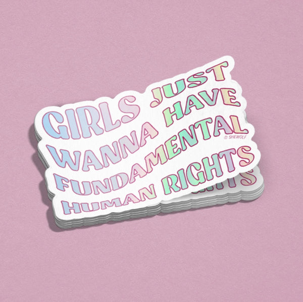 stack of stickers that read Girls just Wanna Have Fundamental human Rights in pastel rainbow bubble font. pink background