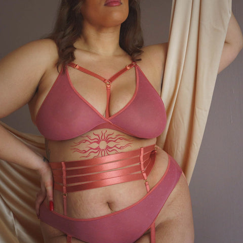 plus size white model is wearing the lg/xl Hearts of Venus Strappy Bralette in Copper Rose with the matching panty and waist cincher