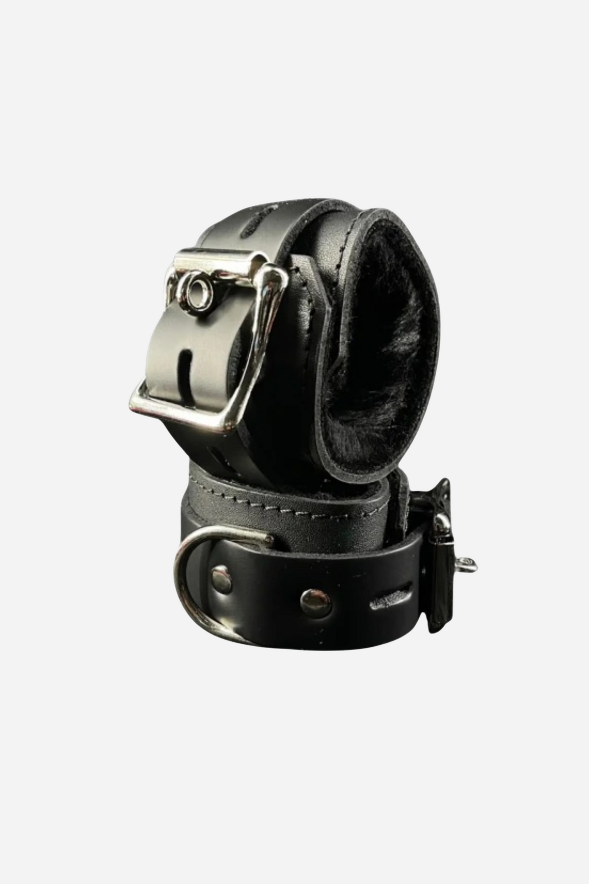 A black leather ankle cuff lined with soft grey fleece, fastened by a buckled strap with a heavy silver D ring set at the side.