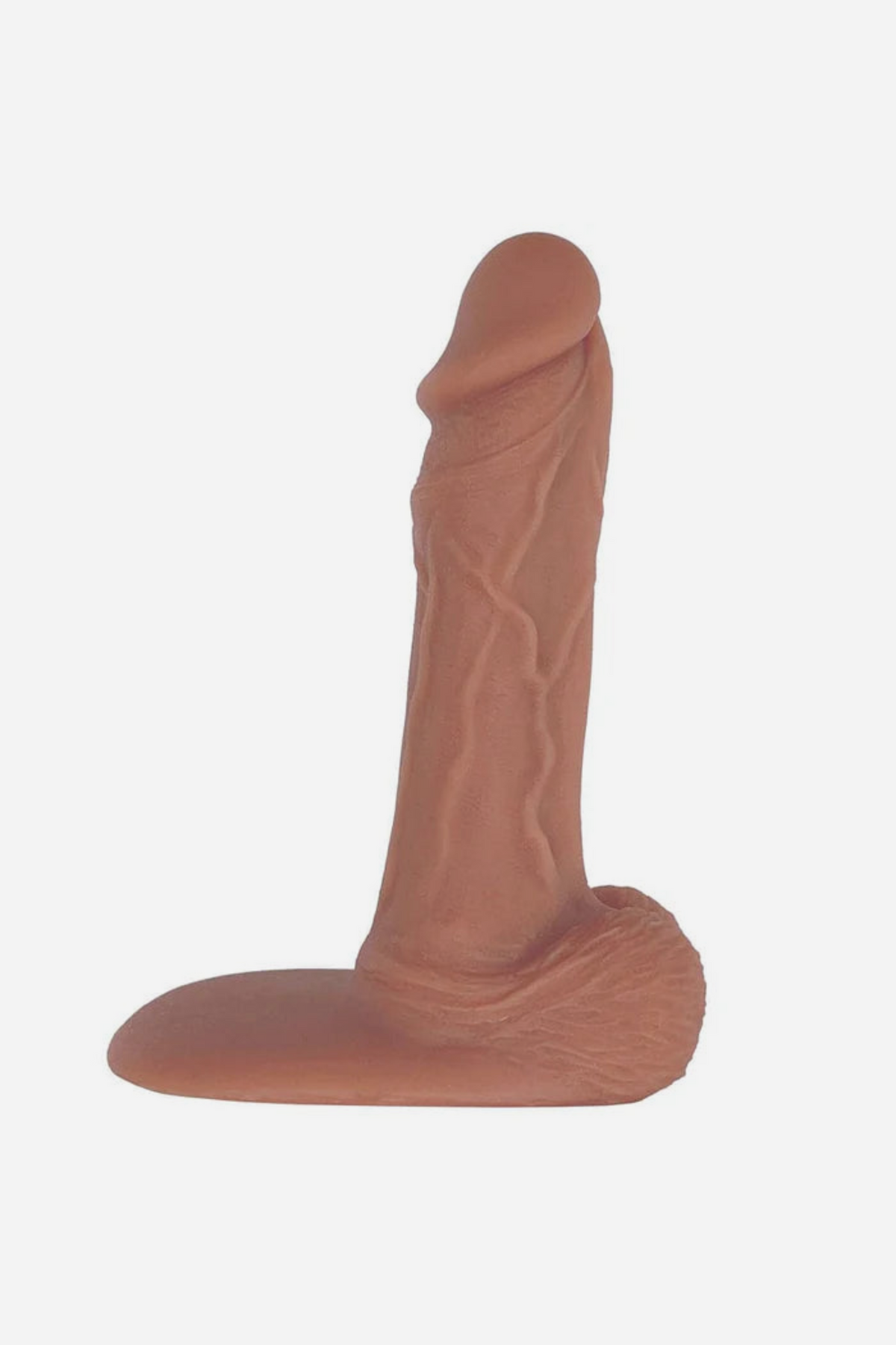 Light caramel Jaxson realistic 7 inch single density silicone dildo with a detailed veined shaft, testicles and flat suction base, on grey