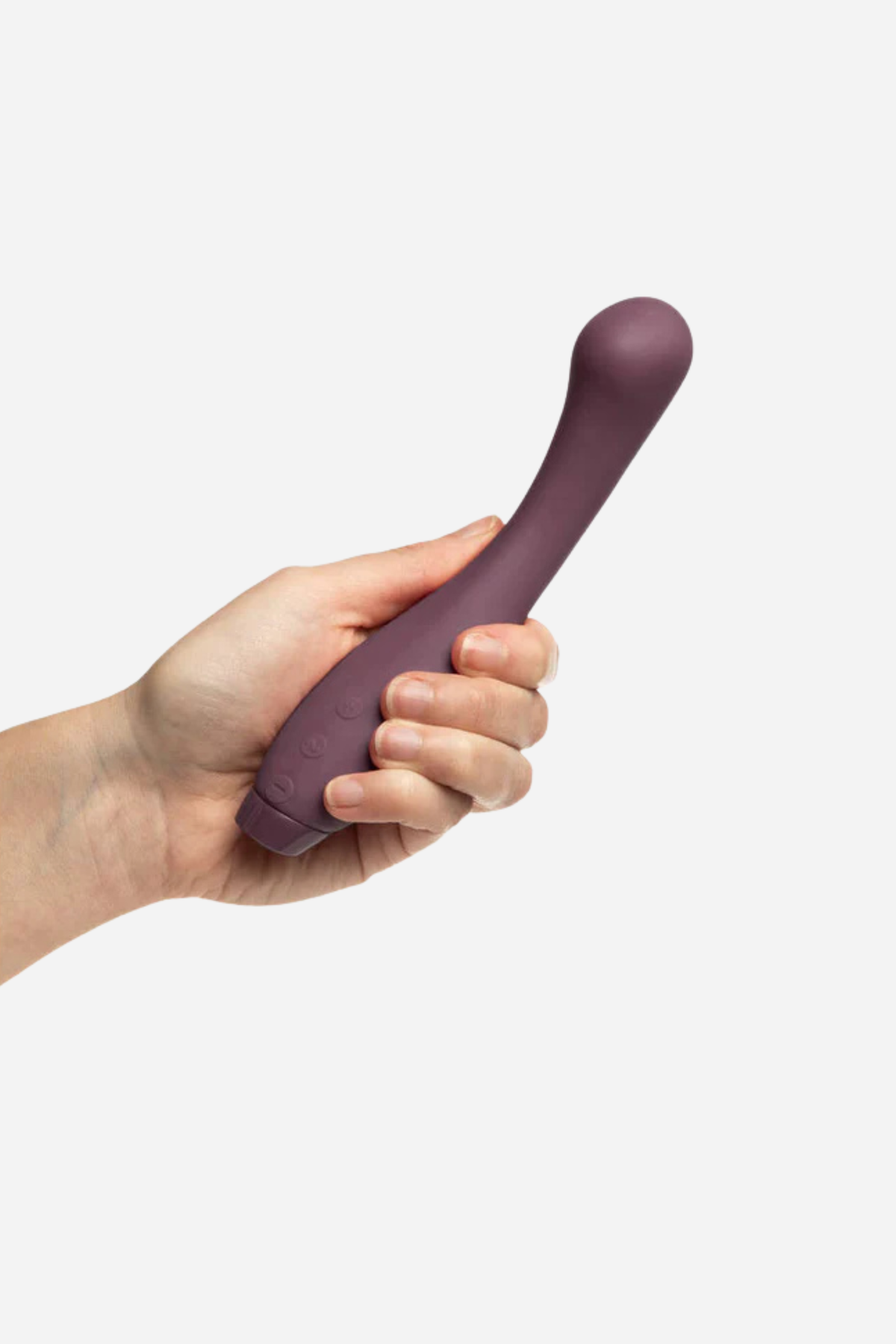 Hand holding the Je Joue Juno G-spot vibrator in Purple, showing its size, curved neck and bulbous G-spot tip on light grey