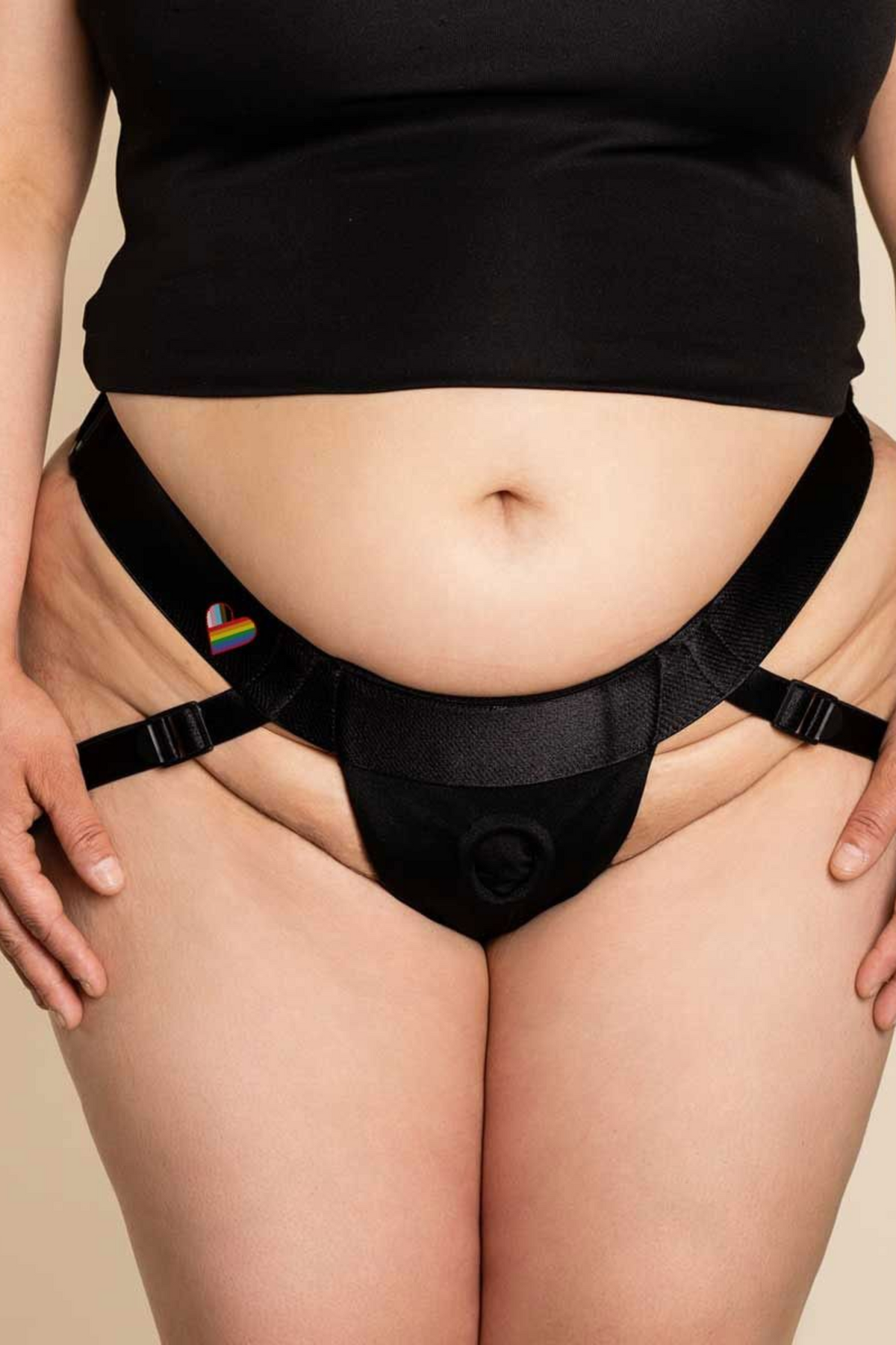 Front view of a plus size model wearing the Jock open butt harness by Wet for Her, showing the O-ring front pouch and straps on cream