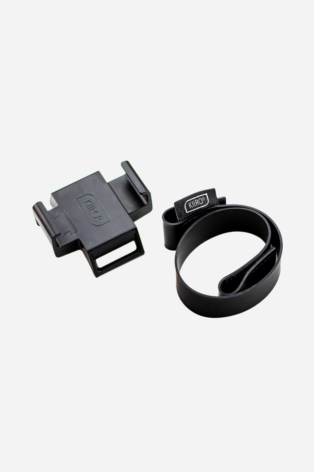 The Kiiroo Keon phone holder accessory, a flat black clamp shown beside the moulded strap that fastens it around the Keon device