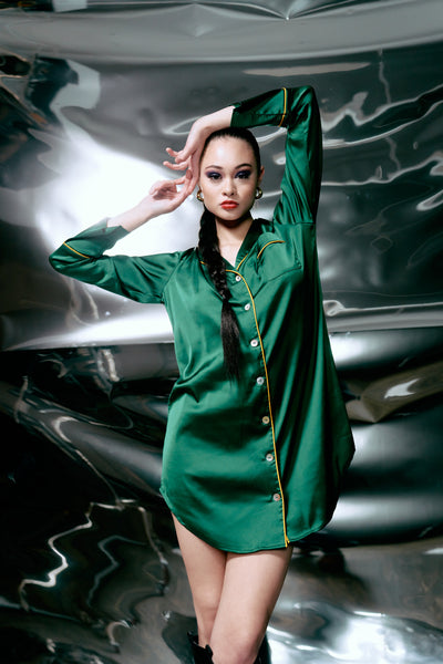 size small pacific islander model with long braided hair poses in Kilo Brava Satin Sleepshirt in Emerald . background is mirrored shiny silver