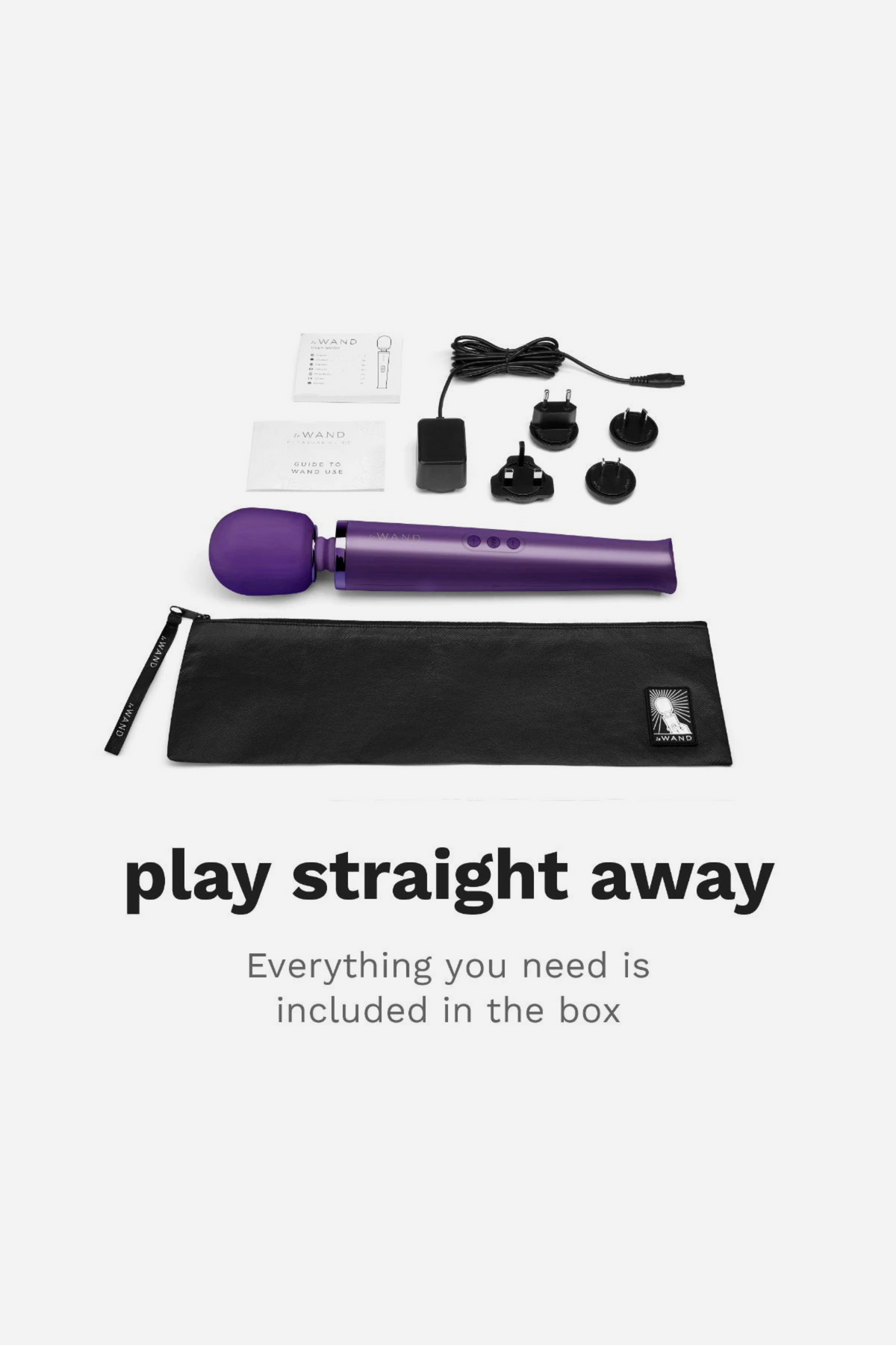 Purple Le Wand Original Rechargeable Wand shown with everything in the box, including charger, plug adapters and storage bag, ready to use