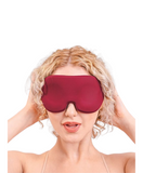 white model with blonde curly hair holds sides of head seductively. model is wearing red memory foam blindfold