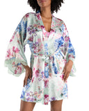 brown model wearing a pale green robe with blue and pink detailed flower print