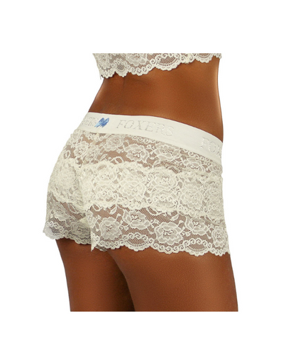 white female model in size small faces away from camera to show off the see through women's lace boxers in ivory with light blue bow on waist