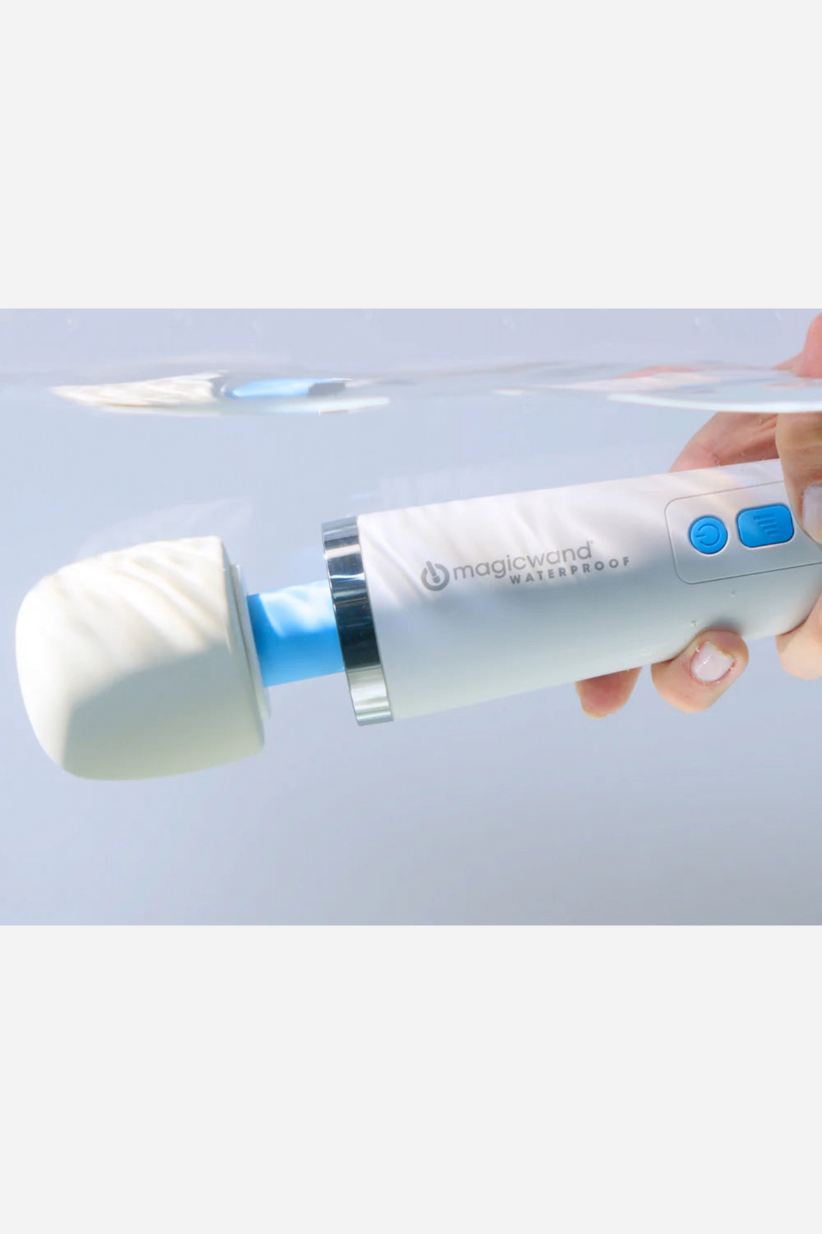 Hand holding the white Magic Wand Waterproof massager under clear water, showing that the cordless wand is fully submersible