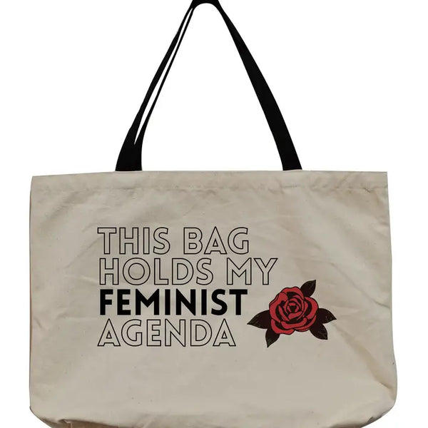 beige tote bag with black handles. Outline-font text reads this bag holds my feminist agenda. Feminist is bolded. A red rose is next to the text