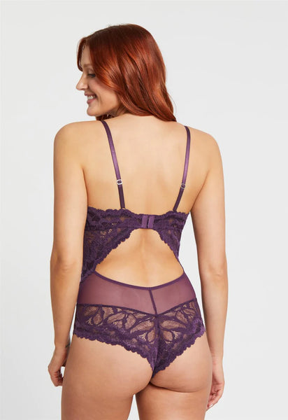 size small redheaded model shows off the back of the lace bodysuit with open back and cheeky cut bottom