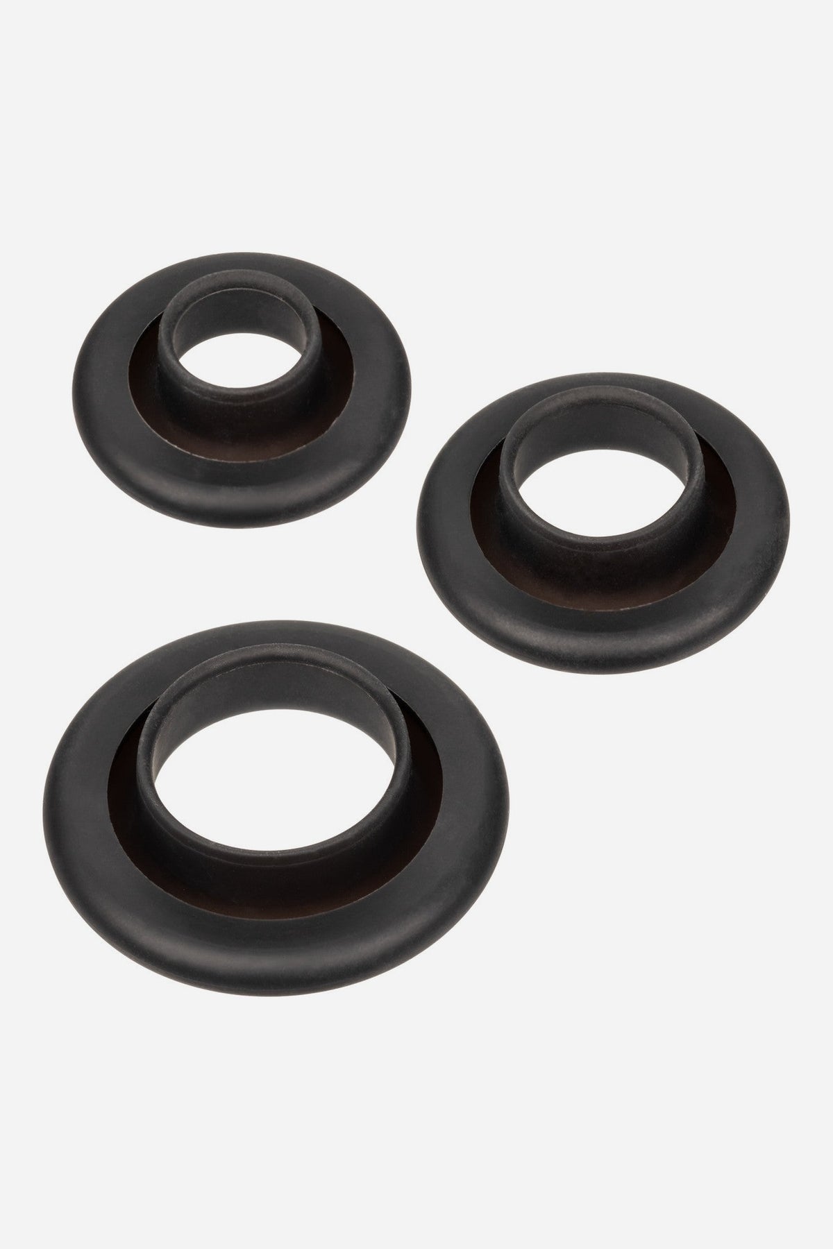 The three black silicone sleeves included with the No Bounds Trans Masc Pump, in three sizes to fit each cylinder, on a light grey background