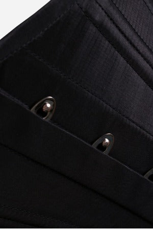 Close-up of the silver busk clasps along the front opening of the black Nobody's Fool waist cincher, showing stitched panels