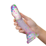 white hand holds up the clear confetti dildo. 