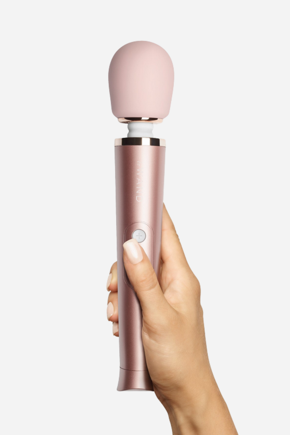 Hand holding the Le Wand Petite massager in rose gold upright, showing the soft silicone head and slim metallic handle of this mini wand