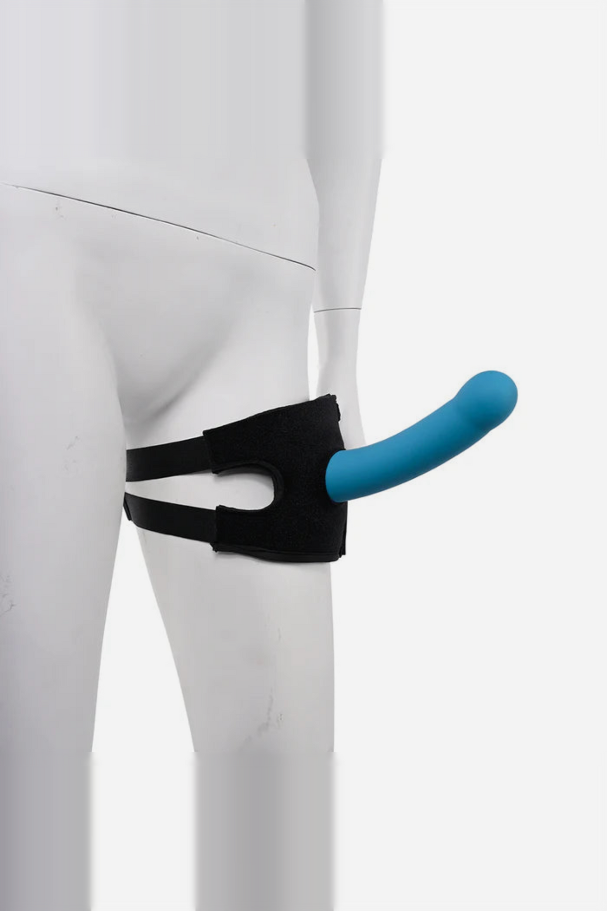 Pivot strap worn on a white mannequin's thigh with a blue dildo mounted through the O-ring, set up as a thigh strap-on for riding
