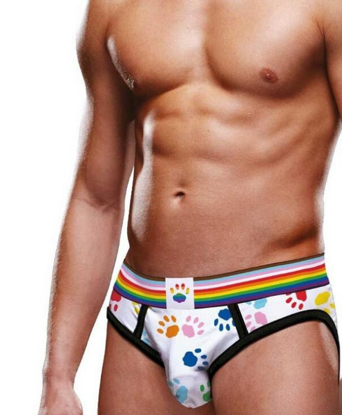 shirtless white male model faces camera to show off the prowler paw print graphics across the front of the briefs. The progress pride flag waistband stands out against the white background of the underwear