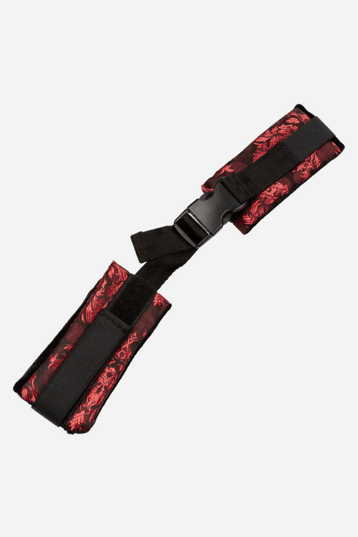 Scandalous Take Control Brocade Cuffs laid at an angle, showing the red brocade fabric, soft lining and black connecting strap and buckle