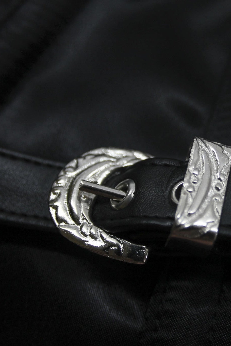 Close-up of the decorative silver buckle and strap on the black satin side panel of the Tempest overbust corset
