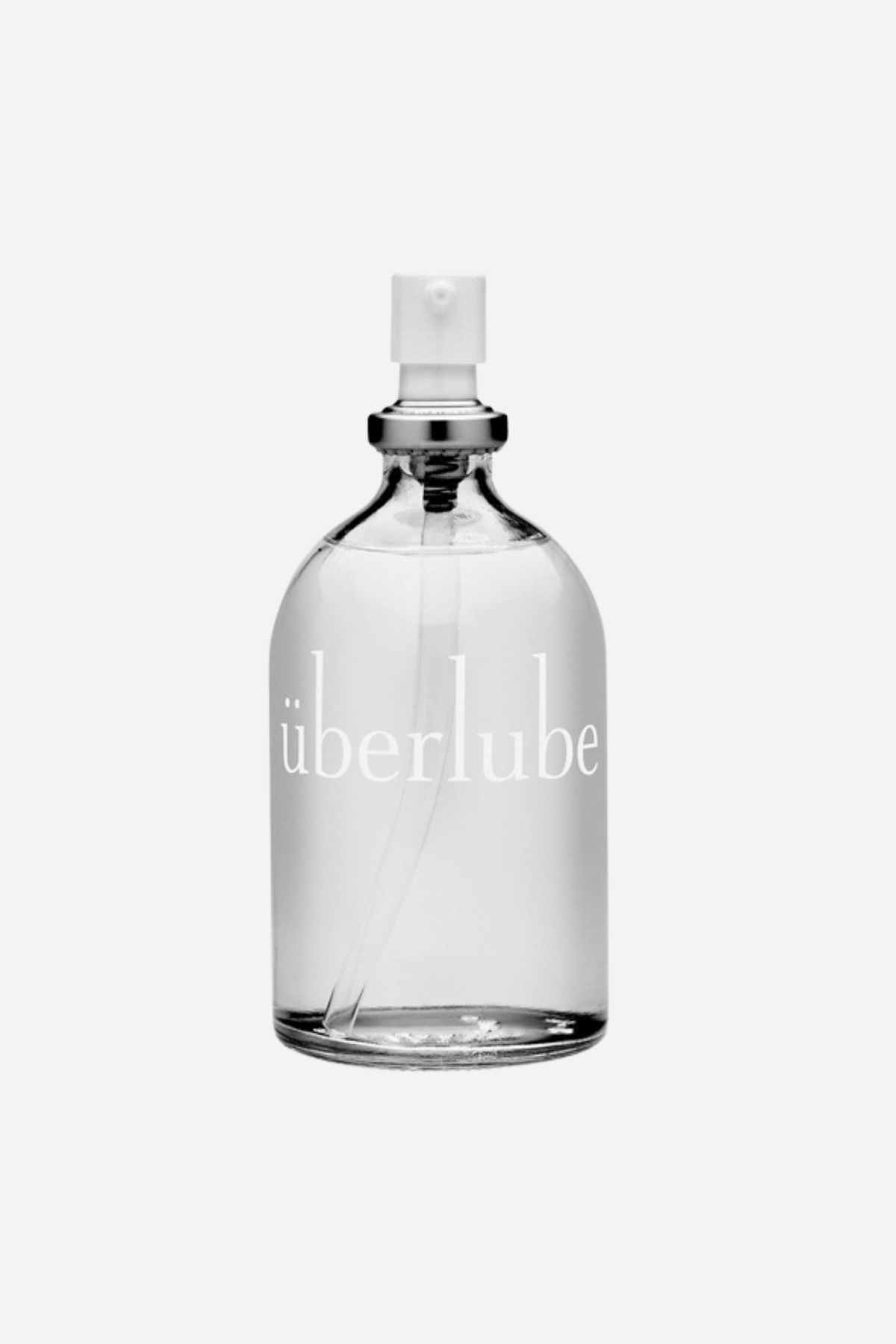 Überlube silicone lubricant in a clear glass bottle with a white pump top and silver collar, shown on a light grey background