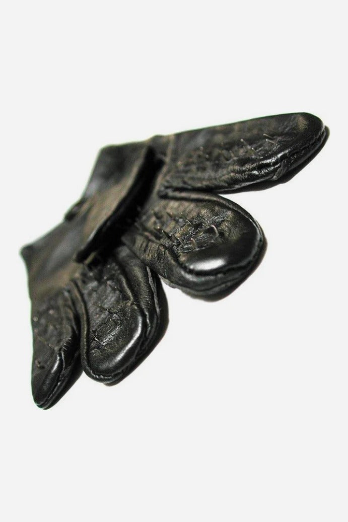 Close-up of the palm side of a black leather vampire glove showing the rows of tiny metal spikes lining each fingertip