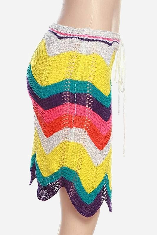 Side view of the Waves of Color crochet midi skirt with rainbow chevron stripes, white drawstring waist ties and wavy hem