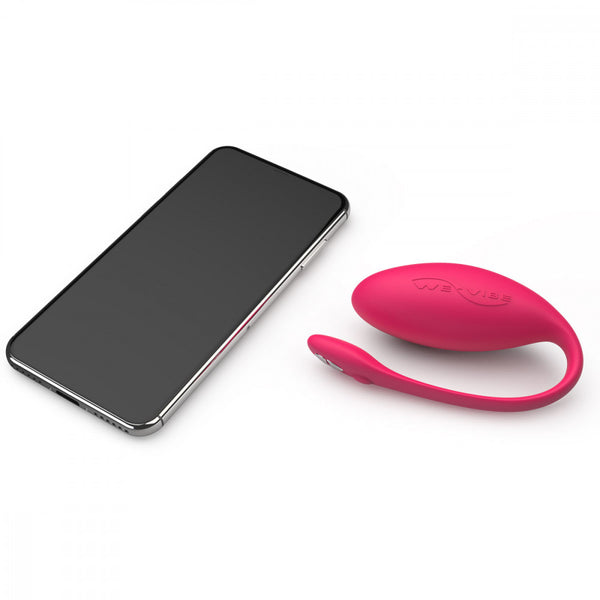 egg shaped panty vibe sex toy in pink next to a cell phone. meant to show that the sex toy can be controlled via the phone app