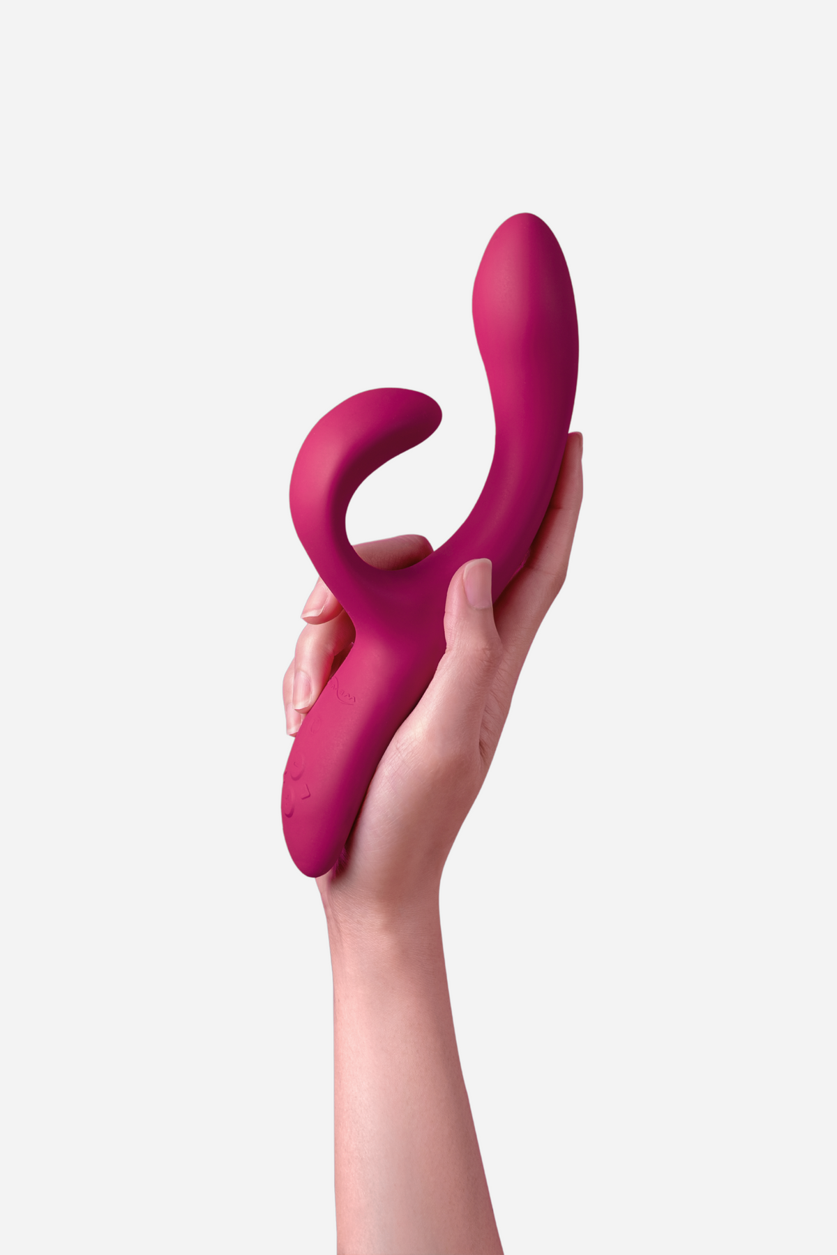 Hand holding the We-Vibe Nova 2 Rabbit Vibe in magenta, showing the flexible clitoral arm and curved G-spot shaft against a grey background