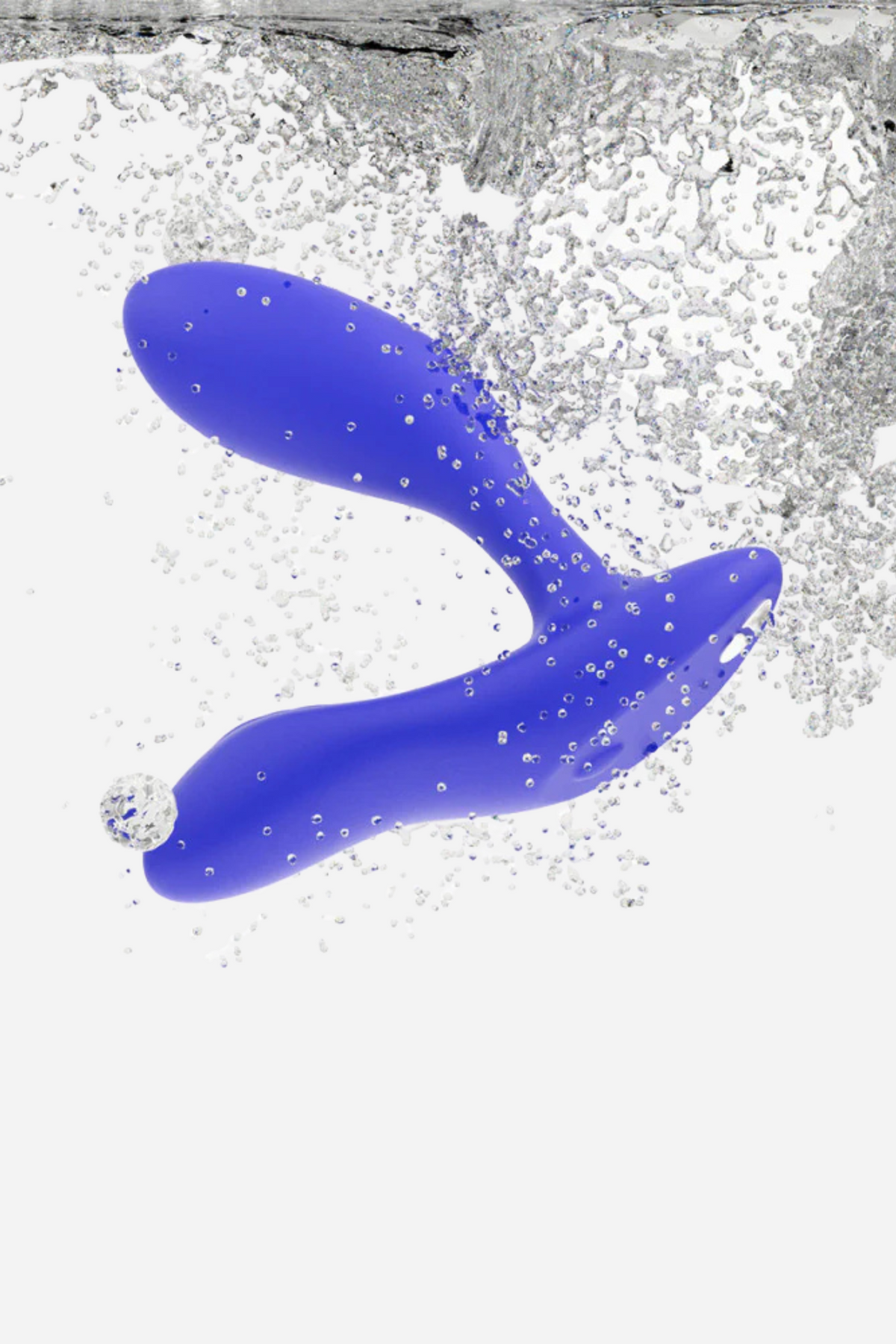 Royal blue We-Vibe Vector+ surrounded by water splashes and bubbles, showing that this rechargeable prostate vibrator is fully waterproof