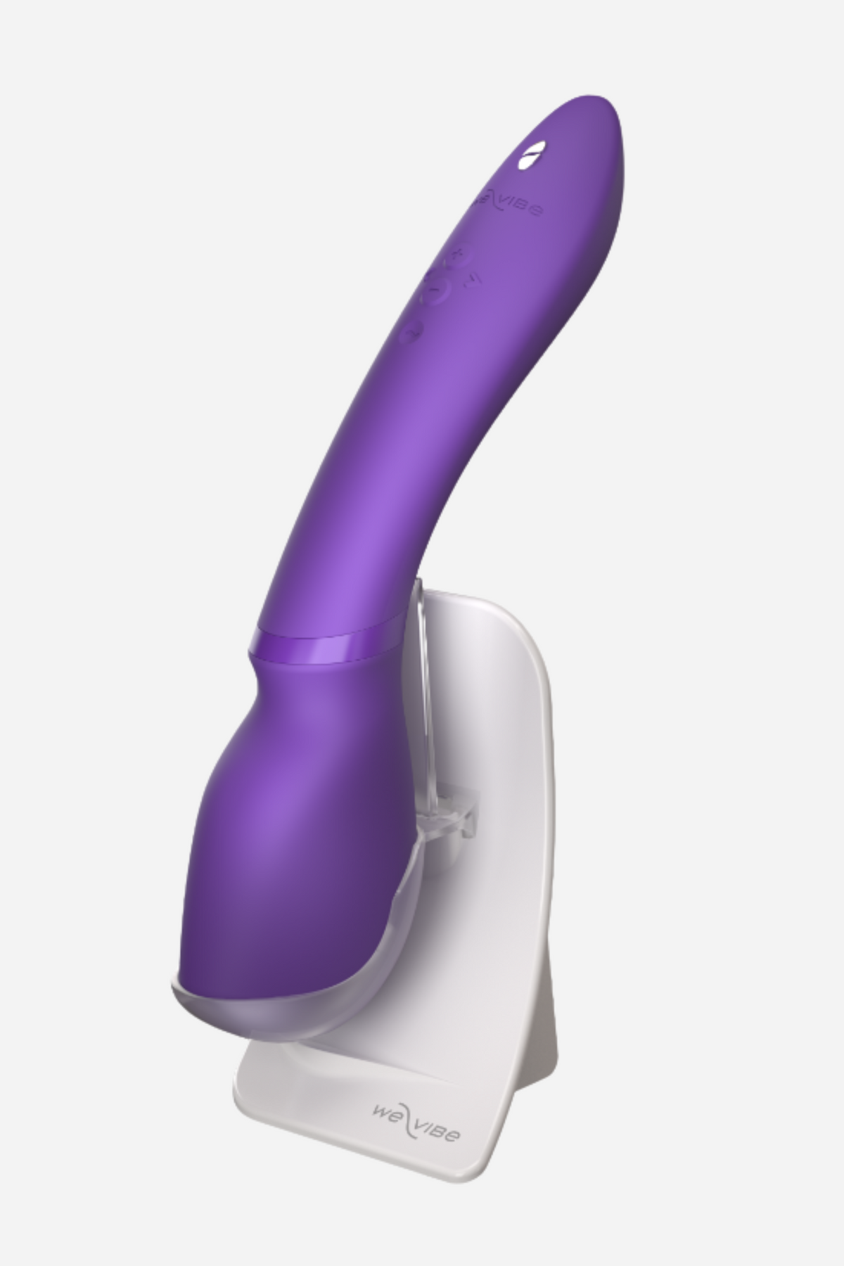 Purple We-Vibe Wand 2 resting upright in its white charging stand, which doubles as a neat storage dock between uses, on light grey