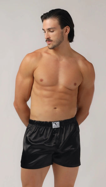 white man with no shirt and defined abs wearing silky black boxers mens lingerie