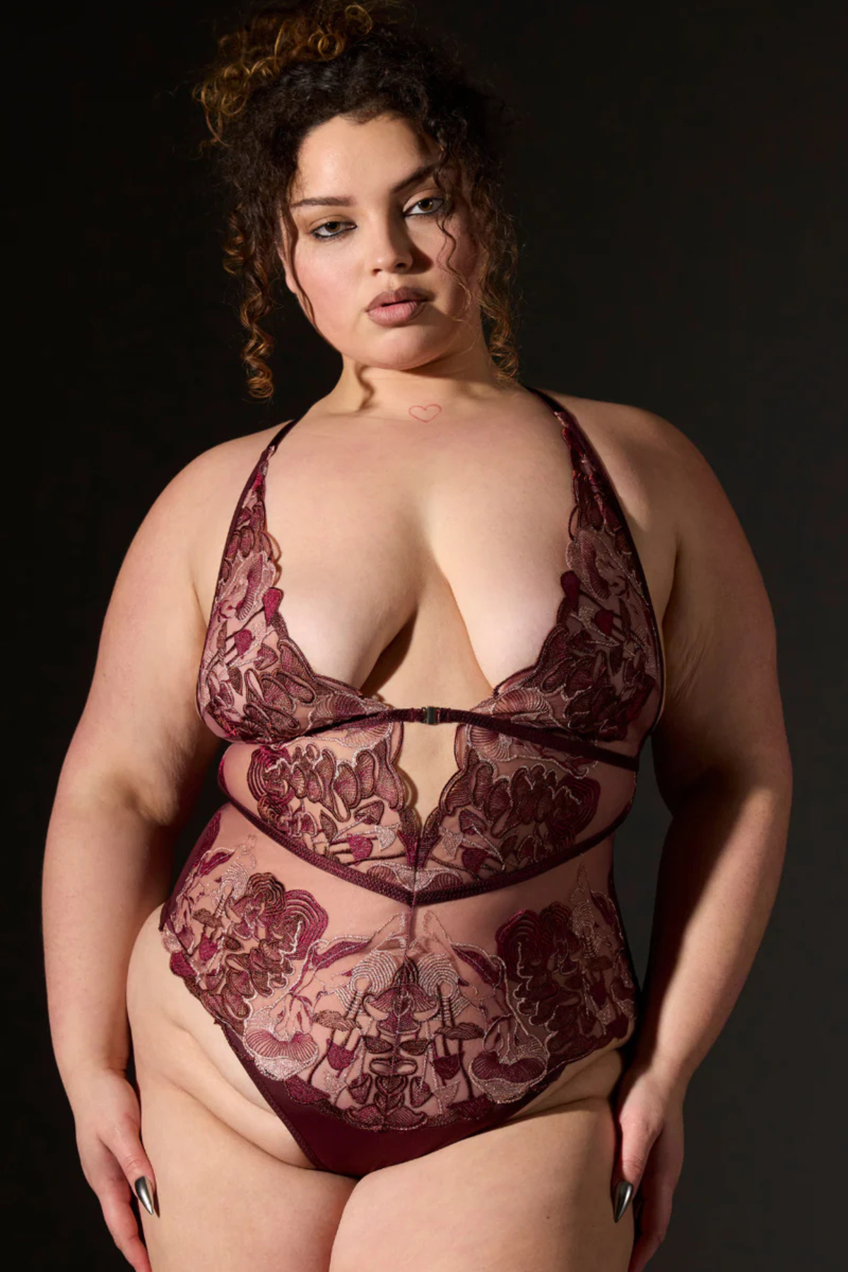 Plus-size model in the Wild Chanterelle Dreams bodysuit in mauve, with mushroom-inspired embroidery, plunging neckline and sheer mesh