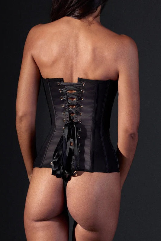Back view of a model in the Wild Chanterelle Dreams corset, showing the waist-cinching black ribbon lacing tied in a bow over the black mesh back