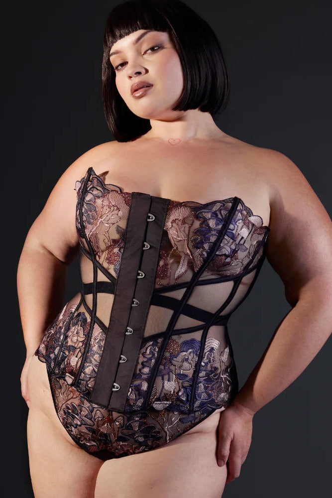 Curvy model in the Wild Chanterelle Dreams corset with hands on her hips, showing the full embroidered front, busk fastening and strappy waist panels